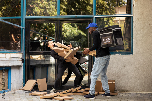 African american delivery man dropping huge pile of pizza boxes on the ground, clumsy poorly trained worker makes a mistake in front of the client. Bad courier service experience.