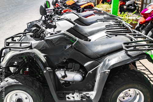 Row of parked motor quad bikes.Modern urban city lifestyle,rent vehicle,lease transportation.sell,buy,loan,insurance.car business.Automobile market industry.