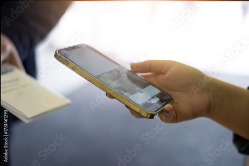 Close-up of woman scanning QR code with smartphone for digital payment or online registration
