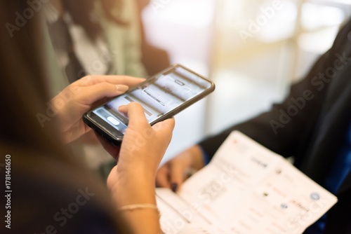 Woman using smartphone to register or check ticket at business event