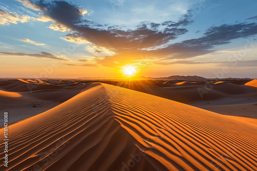 Fototapeta Naklejka Na Ścianę i Meble -  Sand dunes forming perfect lines leading toward a setting sun