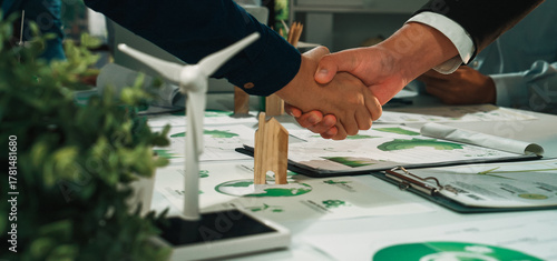 Wallpaper Mural Two business professionals engaging in a firm handshake to seal a deal for an eco-friendly project in a modern office, surrounded by sustainable energy elements. SACTR Torontodigital.ca