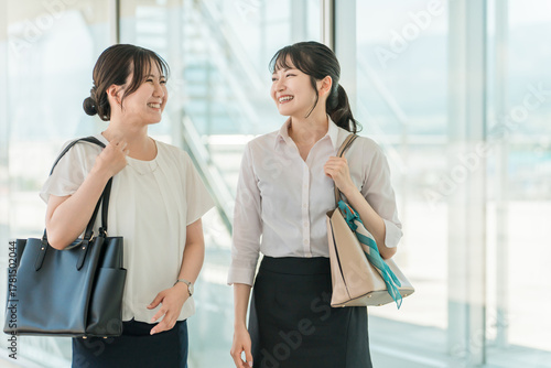 A businesswoman walking with a smile in a business district or office area (commuting, going to work, sales, door-to-door sales)
