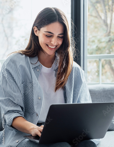 Photography Concentrated millennial girl sit on couch working on laptop browsing internet at