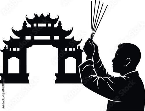 Silhouette of a man praying with incense sticks in front of a traditional asian gate