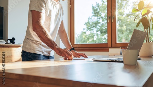 Man Working at a Bright Wooden Desk in a Sunny Home Office