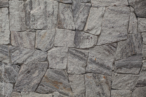 Grey natural stone wall texture: Rustic facade cladding background