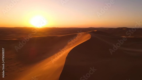 Seamless drone flight over vast, sweeping desert sand dunes, bathed in golden light during sunset environment, untouched, hot