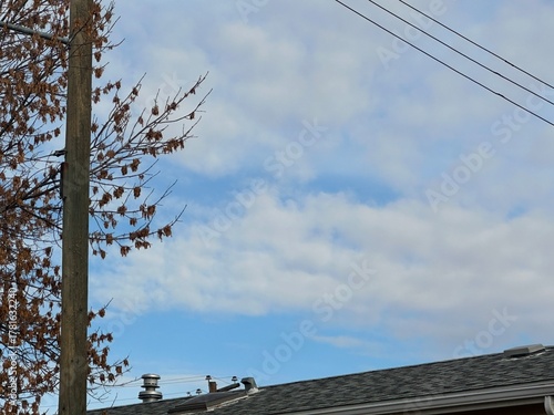 Φωτογραφία view of a residential shingle rooftop under a partly cloudy sky in Alberta, Canada