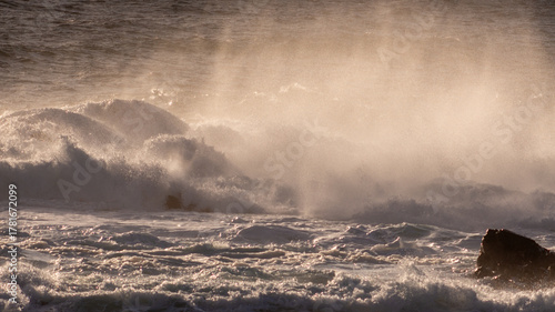 Golden Hour Ocean Spray: Majestic Waves Exploding Against Coastal Rocks in a Dramatic Display of Nature's Power