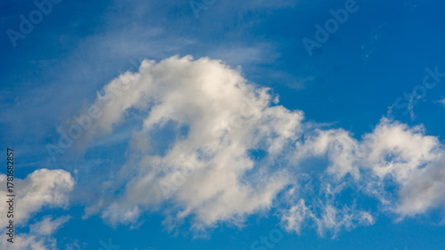 Bright Blue Sky Adorned with Majestic White Cumulus Clouds on a Clear Sunny Day, Showcasing Nature's Serene Beauty and Atmospheric Patterns