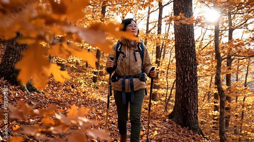 Woman hiking through a vibrant autumn forest with colorful leaves and sunbeams.