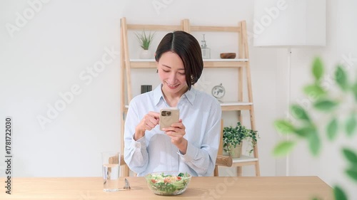 スマホで料理の写真を撮る女性