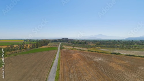 Balat, Turkey. Aerial drone flight over fields approaching ancient city of Miletus, view of the well-preserved ancient Greek Theatre on a sunny day. Aerial View
