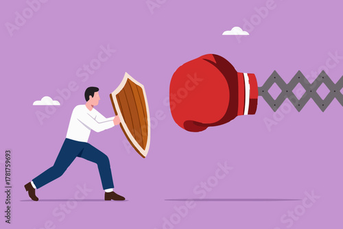 Business threat or problem, challenge or survive to win, survive and struggle to face business competition, defensive businessman using shield to face boxing glove with spring