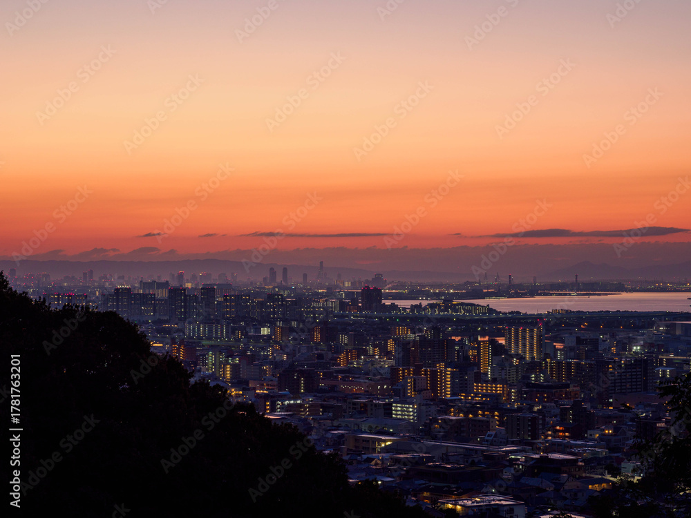 Naklejka premium 都市の夜明け 神戸市東灘区岡本の高台から市街地と大阪湾を隔て大阪市街地の景観