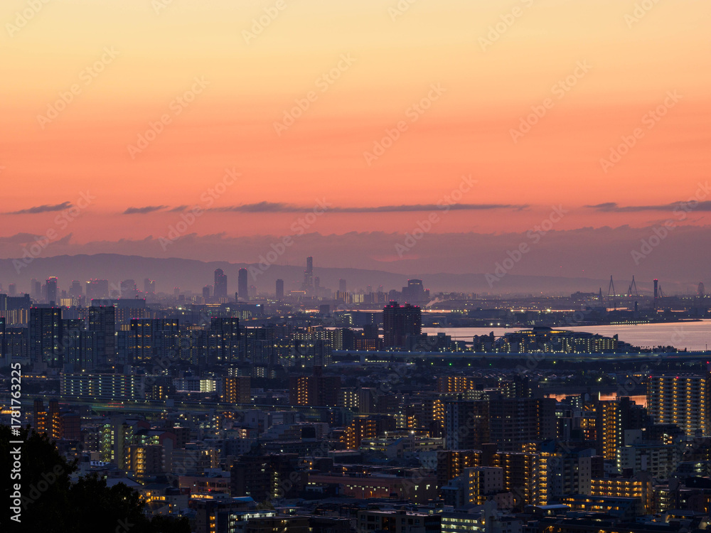Obraz premium 都市の夜明け 神戸市東灘区岡本の高台から市街地と大阪湾を隔て大阪市街地の景観
