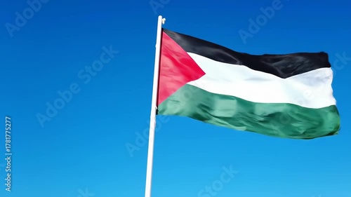The Palestinian flag waves on a sunny day with clear blue sky, for use in media and design