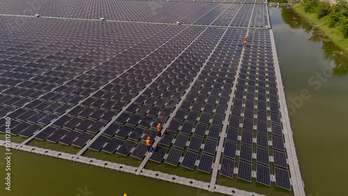 Professional workers clean and inspect solar panels on a floating buoy. Power plant with water	
