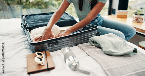 Hands, packing and suitcase with traveler in bedroom of home for holiday, trip or vacation. Clothes, getting ready and luggage bag with tourist person on bed in apartment for travel preparation