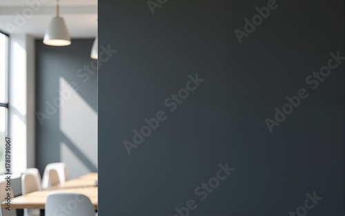 Blank dark wall mockup in modern office interior with blurred meeting room and white chairs in background with copyspace for branding or signage. High quality