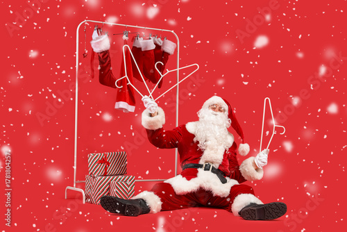 Santa Claus holding hangers...