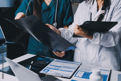 Group of doctors attending seminar in hospital lecture hall with senior physician giving medical presentation and professional training session on healthcare practices