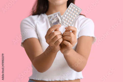 Young woman with condom and...