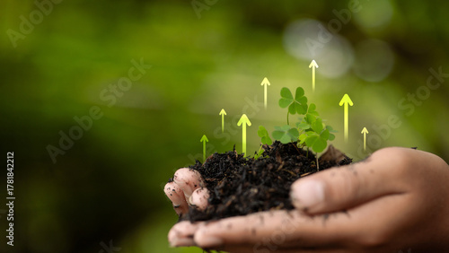 Hands holding soil with young plant and green growth arrows, sustainability and environmental concept