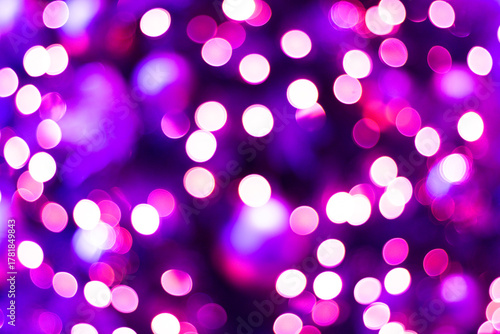 Purple bokeh background with bright, glowing magenta and pink circles, creating a vibrant, abstract, and festive light pattern