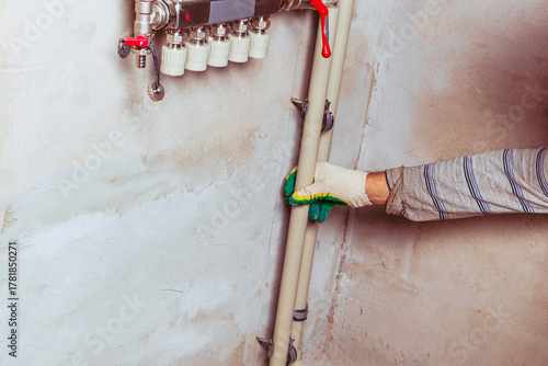 Modern plumbing distribution manifold installed on a concrete wall in a residential building's utility area
