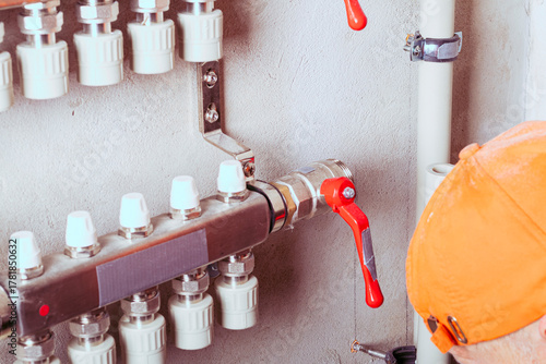 Modern plumbing distribution manifold installed on a concrete wall in a residential building's utility area