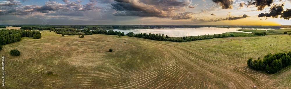 Obraz premium Panoramic aerial view of Stary Staw in the Barycz Valley, Poland, at sunset with meadows and surrounding forests