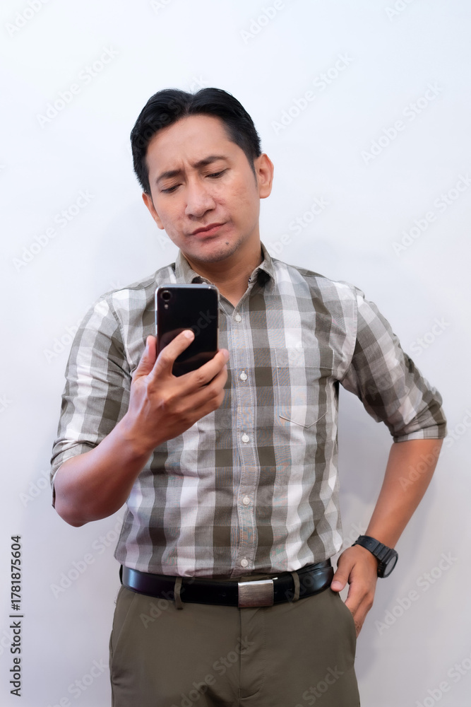 Fototapeta premium Shocked man looking at smartphone screen with surprised reaction, white background