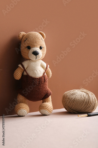 Knitted bear toy with yarn ...
