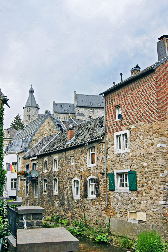 Fototapeta premium View from Stolberg: old houses built along the Vichtbach River and the castle in the background. Represents picturesque Rhineland heritage, German townscape, and authentic European travel atmosphere.