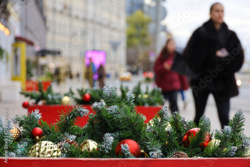 New Year decorations in city, red and golden Christmas balls on a street on blurred background of people