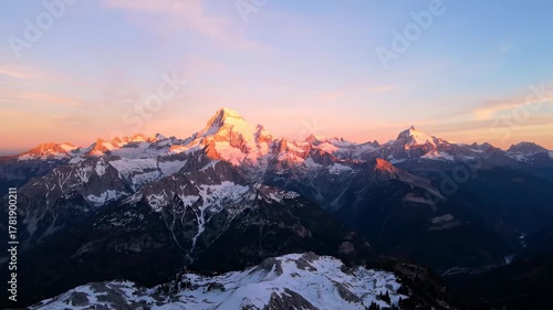 Majestic mountain range aerial view at sunrise with golden light illuminating peaks majestic, golden, serene