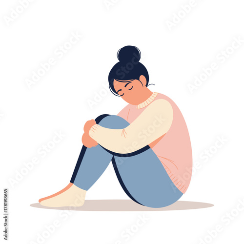 Sad woman hugging knees while sitting on floor, white background