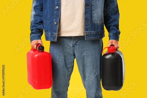 Obraz na plátně Mature man with canisters on yellow background