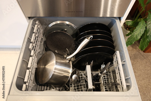 Open dishwasher drawer with dishes
