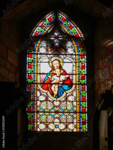 Stained glass window depicting madonna and child in church