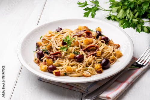 Linguine con alici, olive nere e pane croccante, pasta italiana 