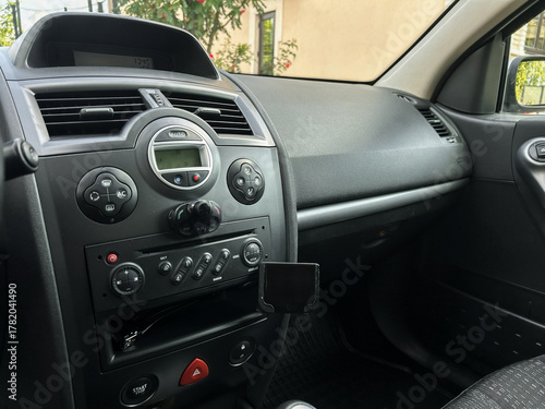 Interior of a modern car showcasing dashboard controls and center console on a sunny day in an urban setting