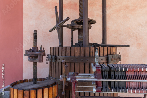 Old olive oil press made of wood and metal, featuring large screw mechanisms and gears once used for traditional olive pressing