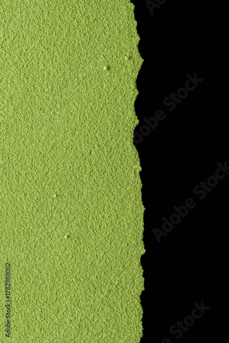 Textured edge of green matcha powder sharply contrasting against black background offers dramatic layout for bold design concepts