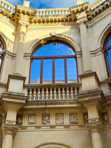 Wallpaper Mural Beautiful architectural details of a historic building in a sunny afternoon, showcasing intricate carvings and large windows reflecting blue sky Torontodigital.ca