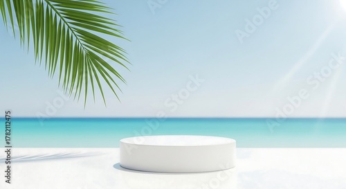 Fototapeta Naklejka Na Ścianę i Meble -  Empty white podium on a tropical beach with palm frond and ocean backdrop for product display