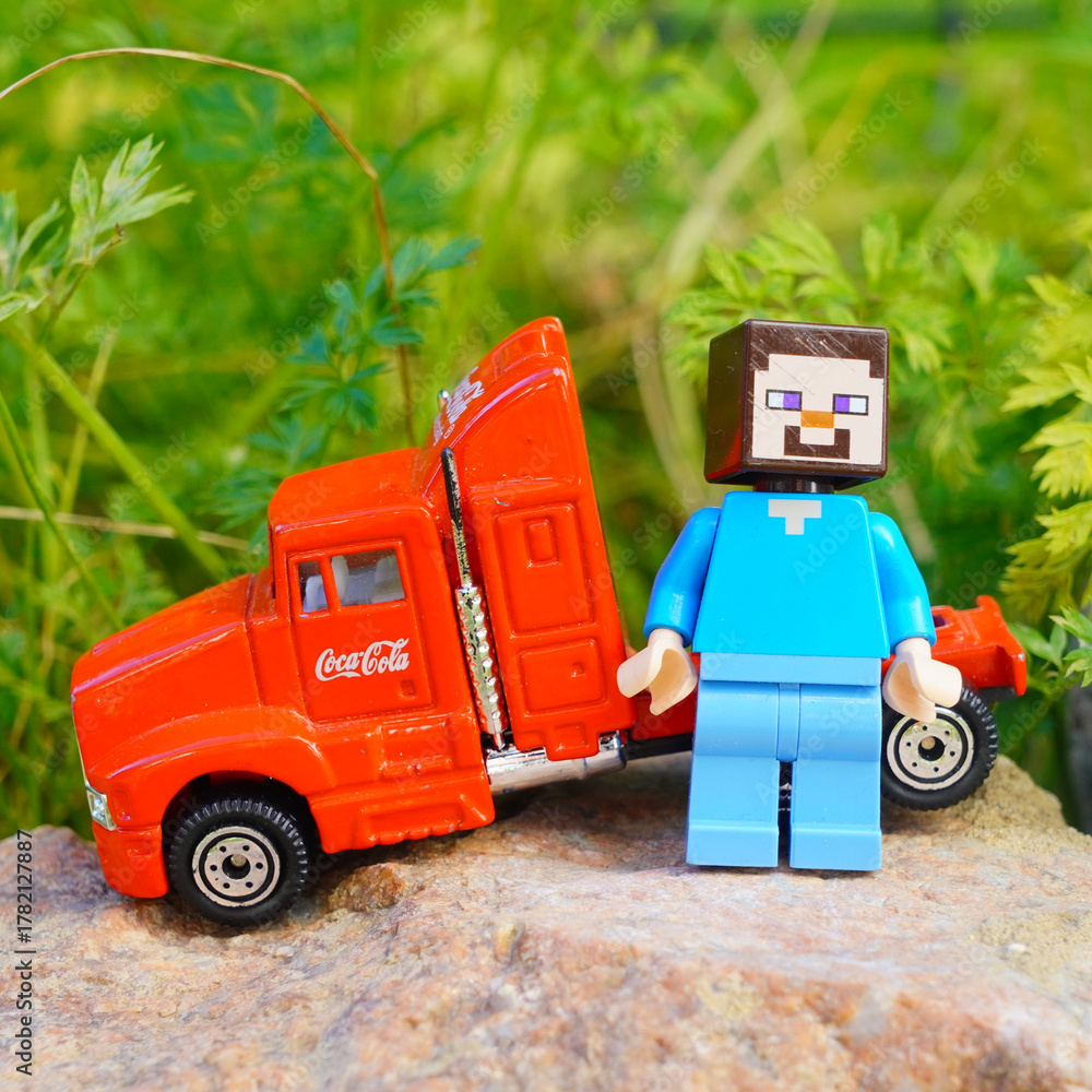Naklejka premium Minecraft Steve figure with a red Coca-Cola truck on a rock outdoors