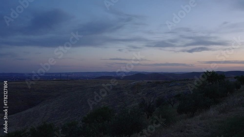 Distant view of Sanliurfa Haliliye city at dusk with lights turning on, filmed from Göbeklitepe